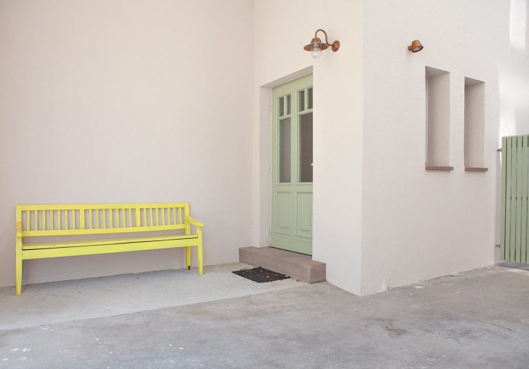 grüne Tür mit gelber Bank Julian Wolf Architektur Umbau zum Wohnprojekt