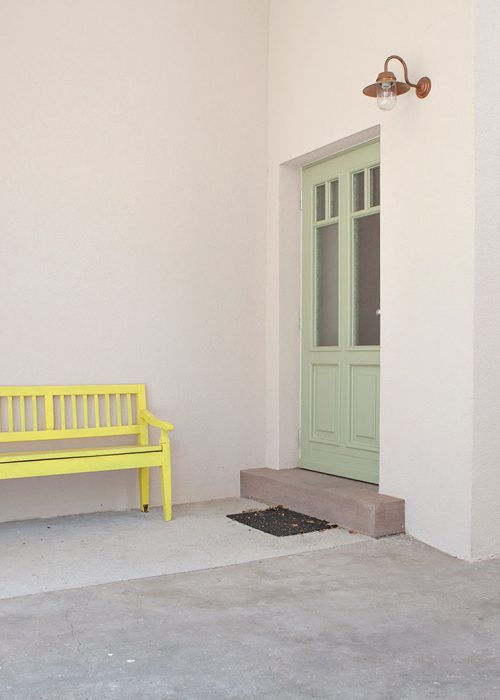 grüne Tür mit gelber Bank Julian Wolf Architektur Umbau zum Wohnprojekt
